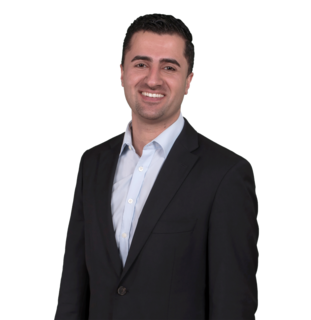 Person im dunklen Anzug vor schwarzem Hintergrund